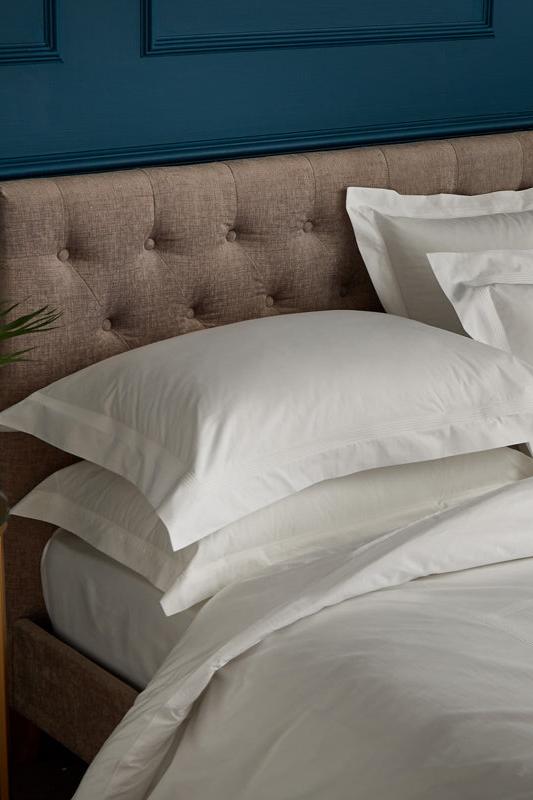 Peter Reed bedding and pillows on bed