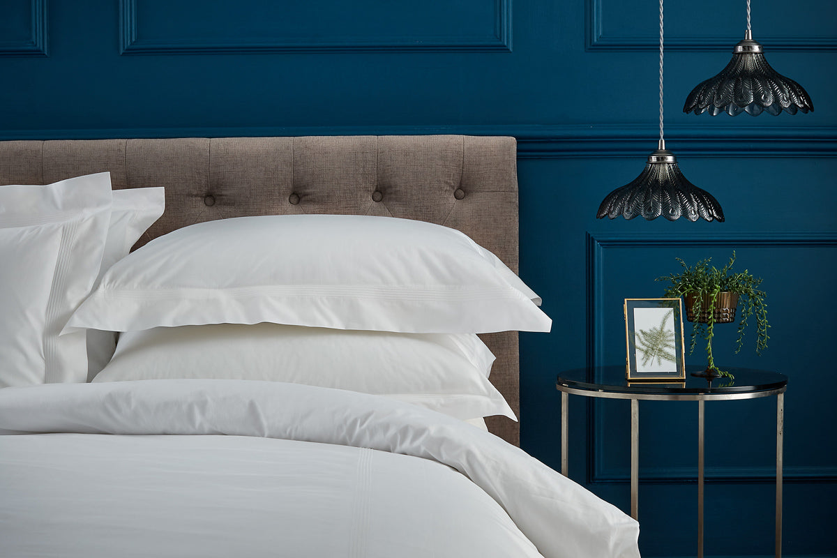 Peter Reed bedding on a bed with blue wall