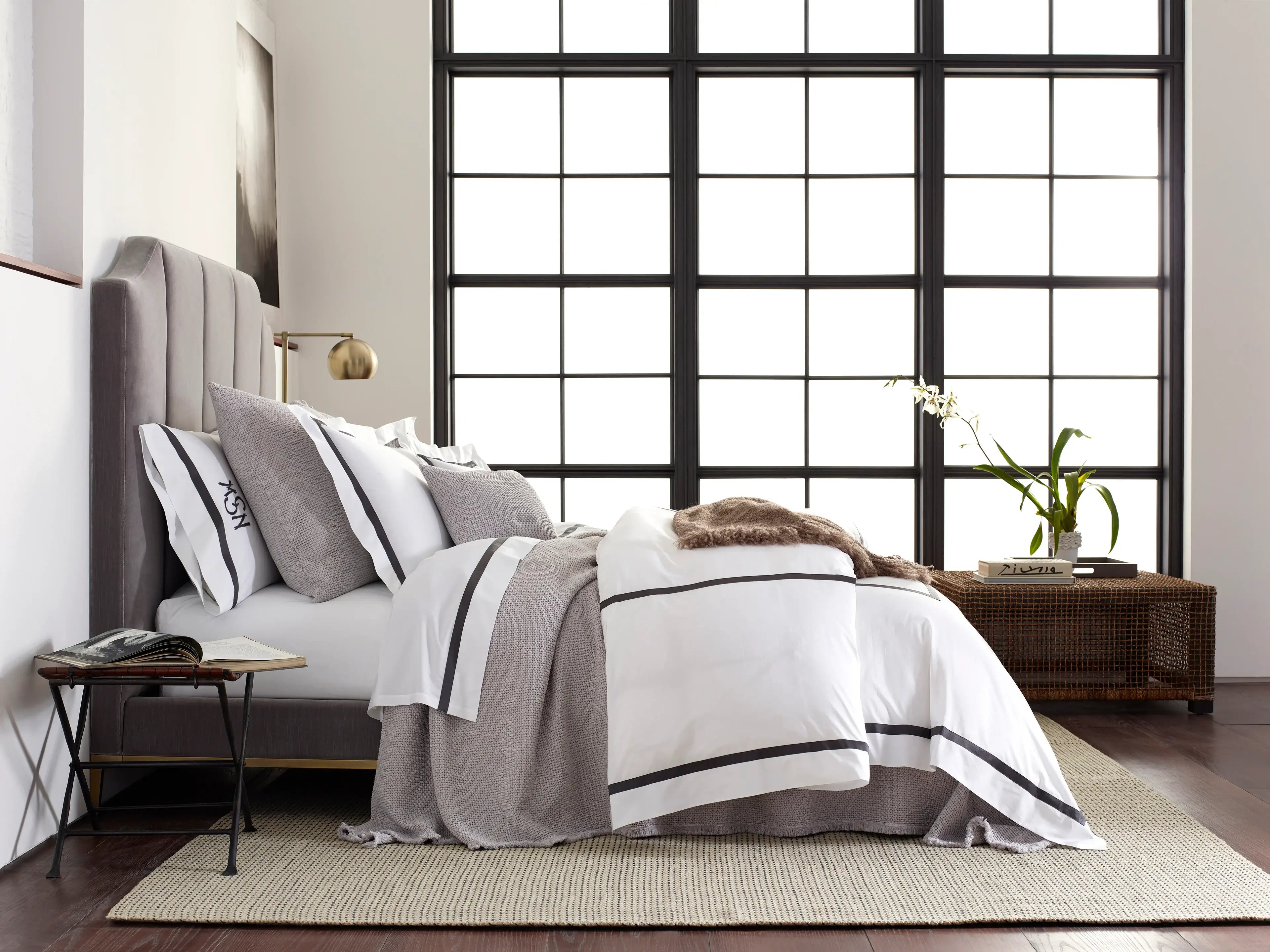 Matouk Lowell Bedspread in white and black with loft style window behind