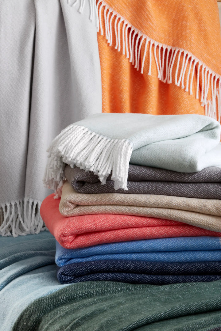 Stack of different coloured Matouk Pezzo Throws