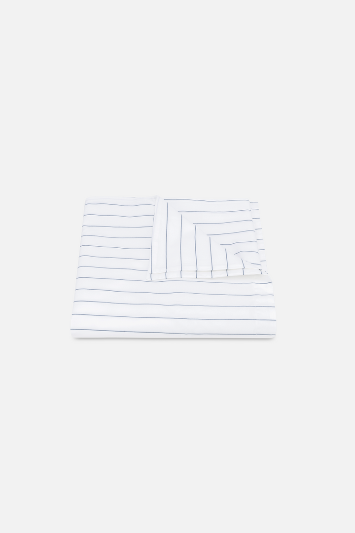 A Matouk Amalfi pinstripe duvet cover in Mediterranean blue, with a hidden zipper closure.