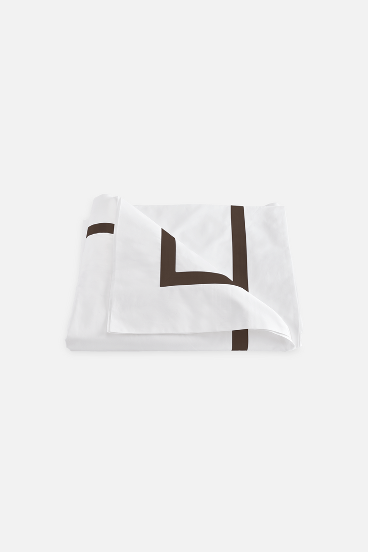 A Lowell Duvet cover in Sable color, showcasing a crisp white percale with a luminous sateen border.