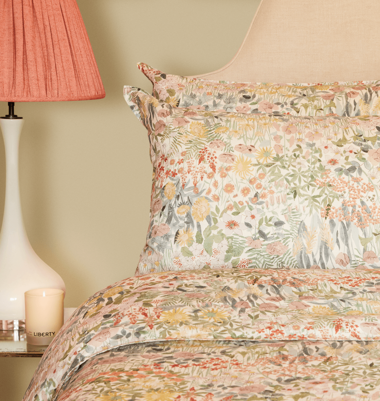 Liberty London Faria Print bedding on a bed beside a bedside table