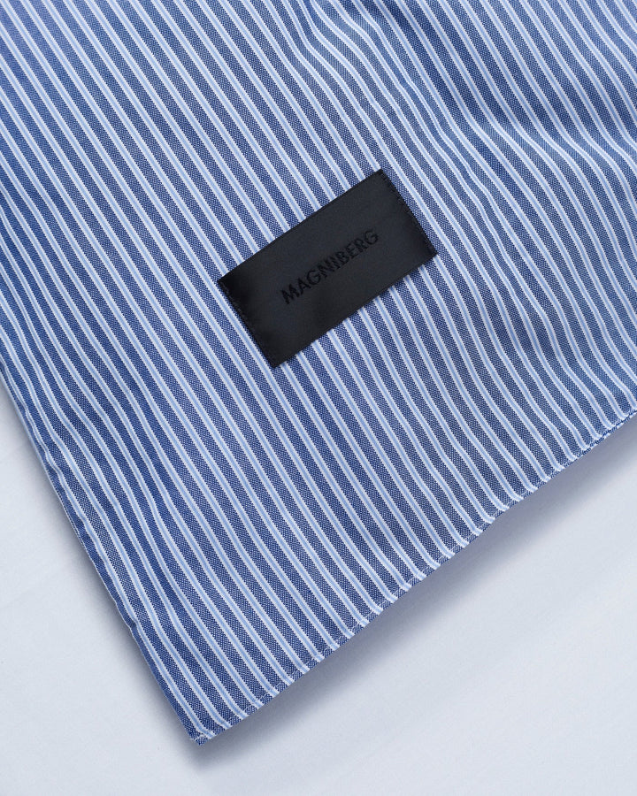 Corner of the Magniberg Wall Street pillowcase in dark stripe