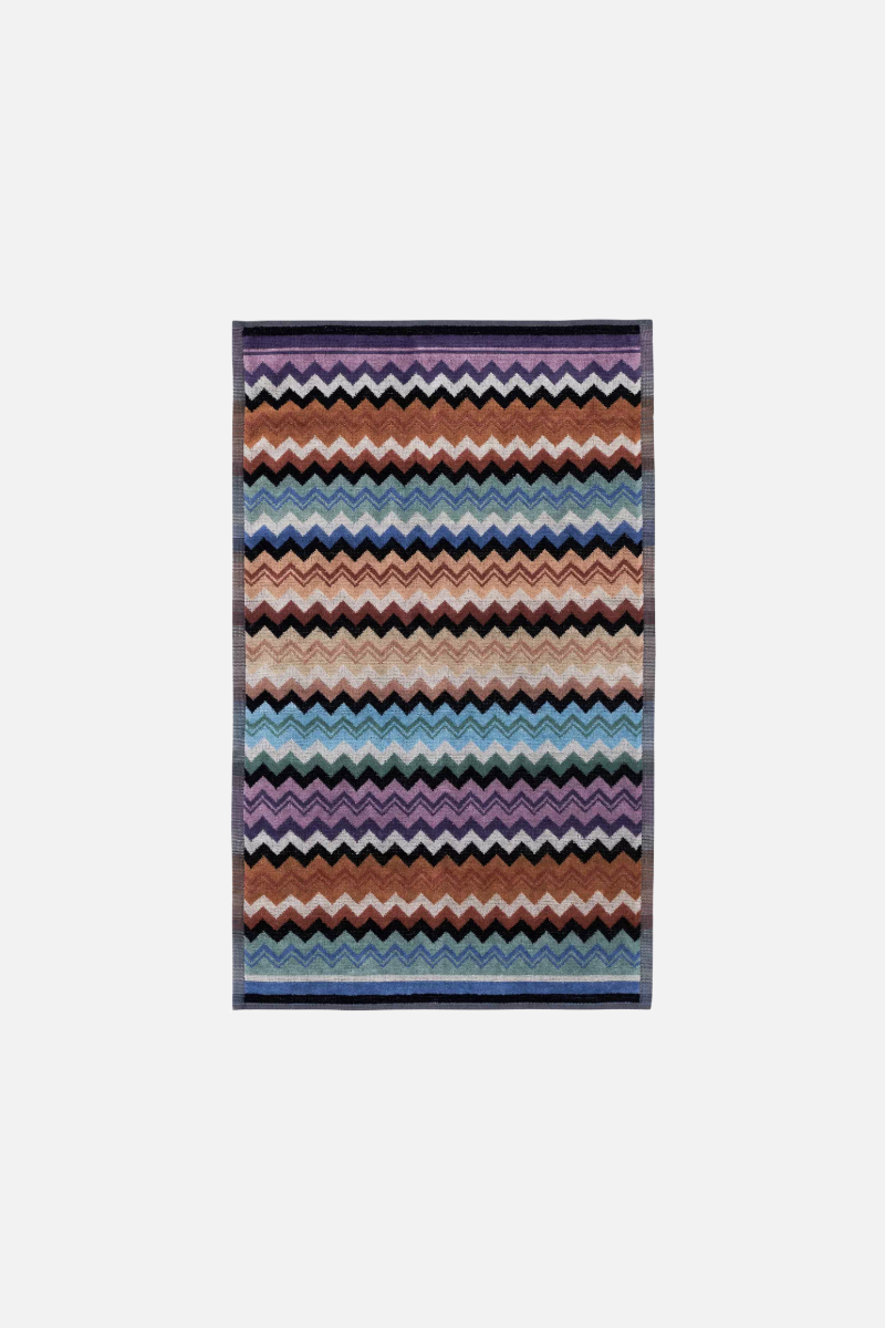 Multi-coloured zigzag patterned towel on a white background
