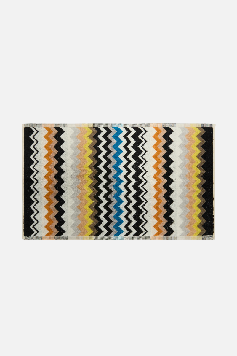 Rectangular rug with colorful zigzag pattern on a white background