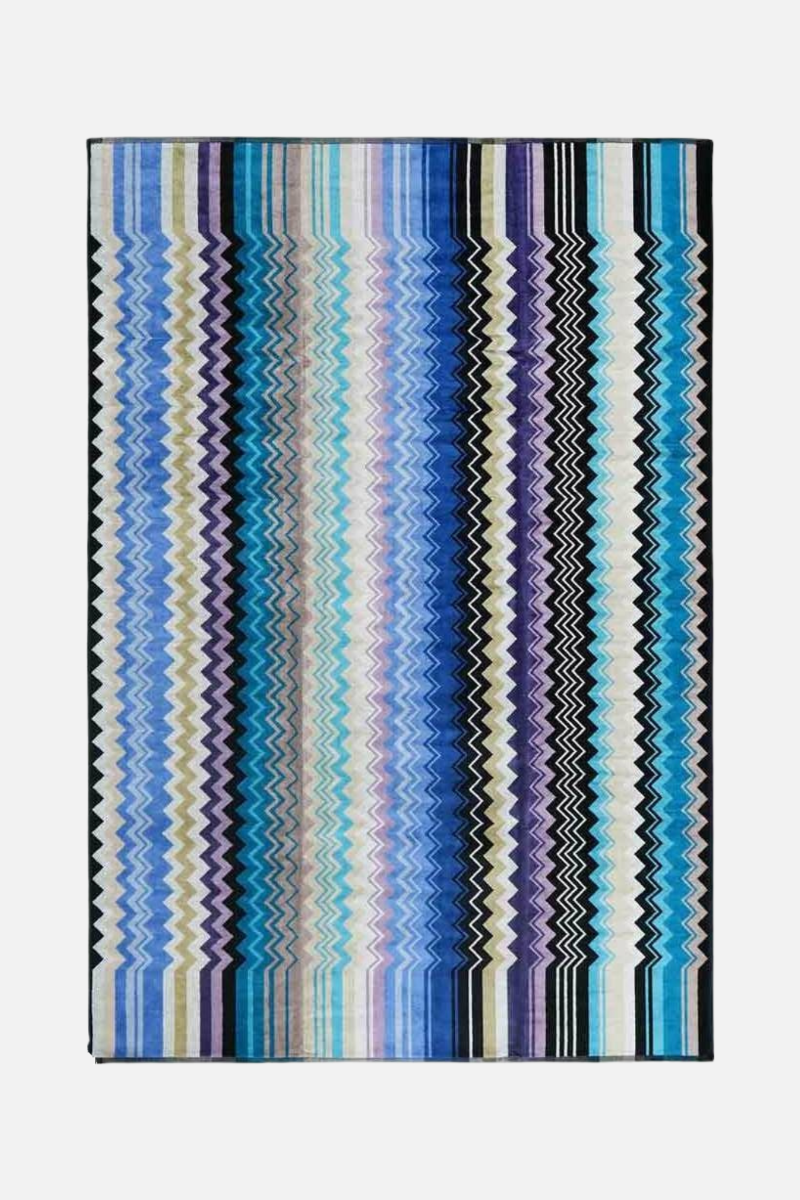 Multicolored striped rug with a zigzag pattern on a white background