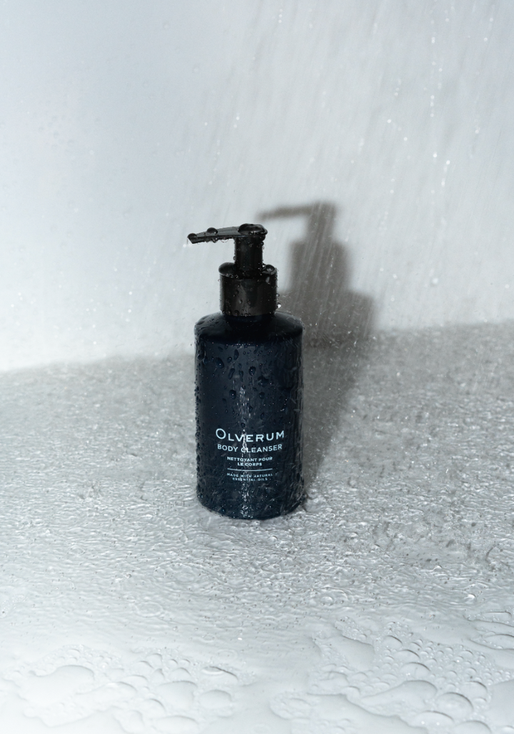 Black bottle with pump labeled 'Olverum' on a textured white surface