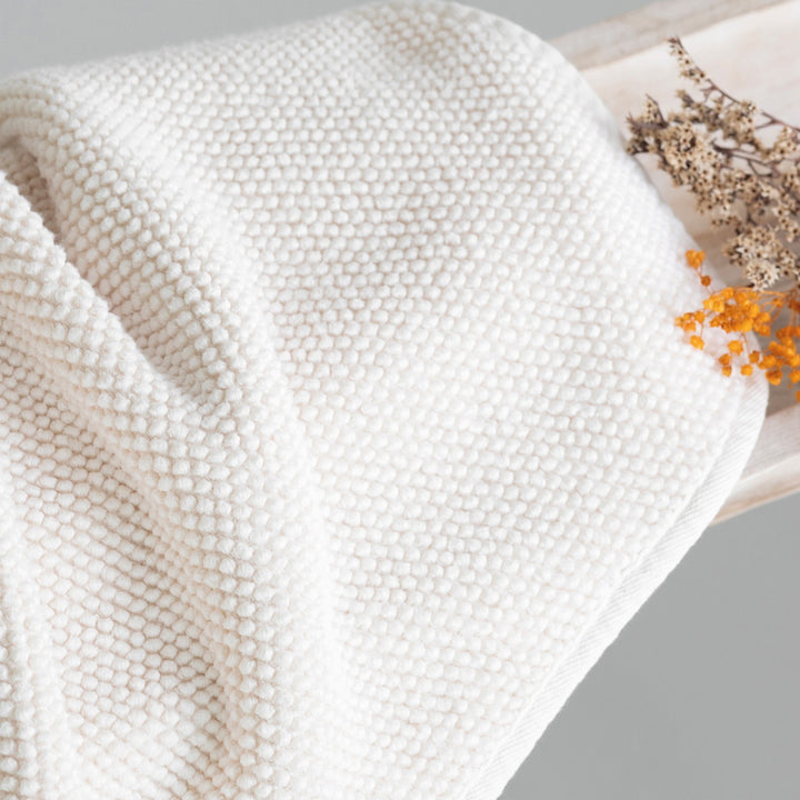 Graccioza Pearls Close-up of a textured white towel with dried flowers on a gray background