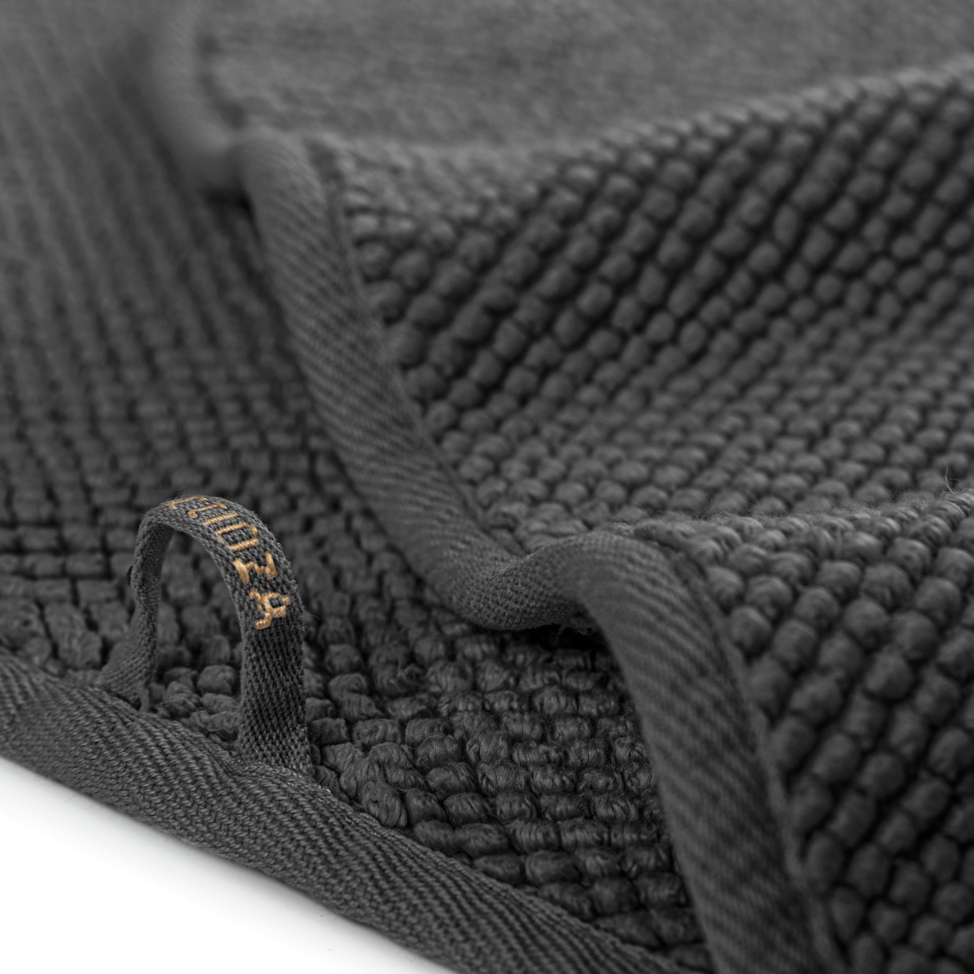 Graccioza Pearls Close-up of a textured dark gray towel with a brand label.