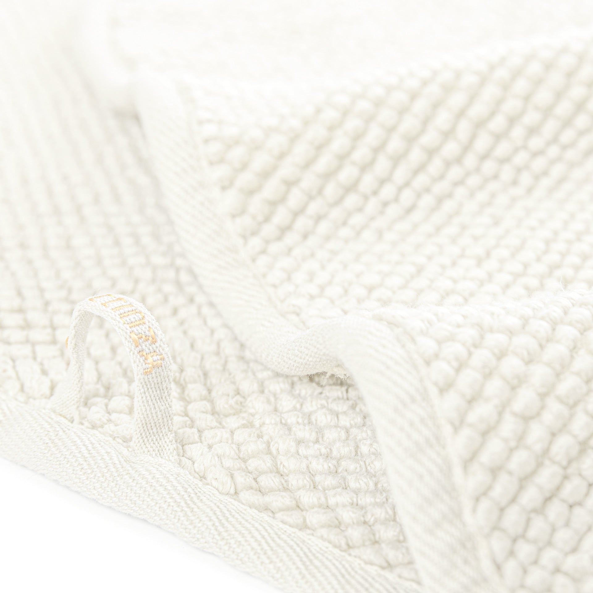 Graccioza Pearls Close-up of white textured towel with a brand label.