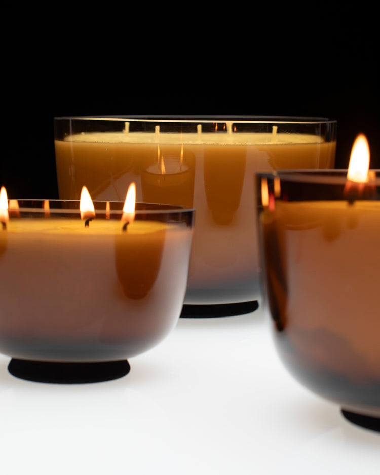 Serrax Vincent van Duysen Candle holders with lit candles on a reflective surface