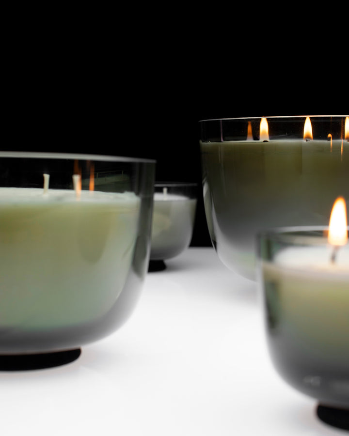 Candle holders with lit candles on a dark background serax vincent van duysen