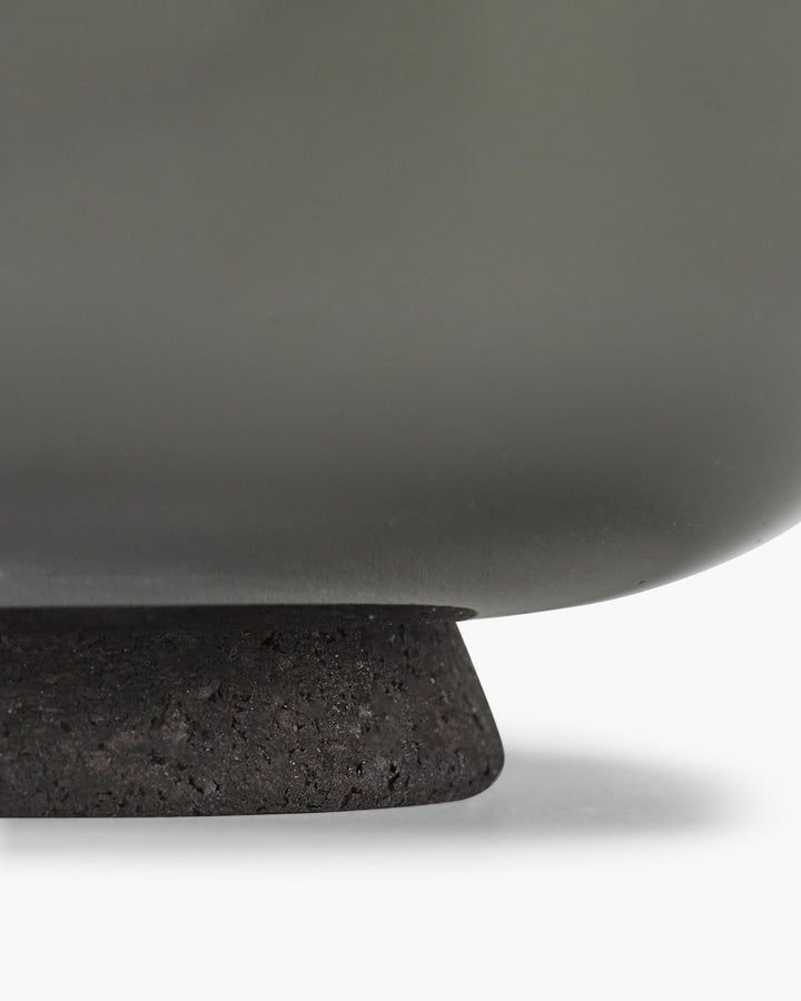 Close-up of a dark gray ceramic bowl with a textured base on a white background serax vincent van duysen