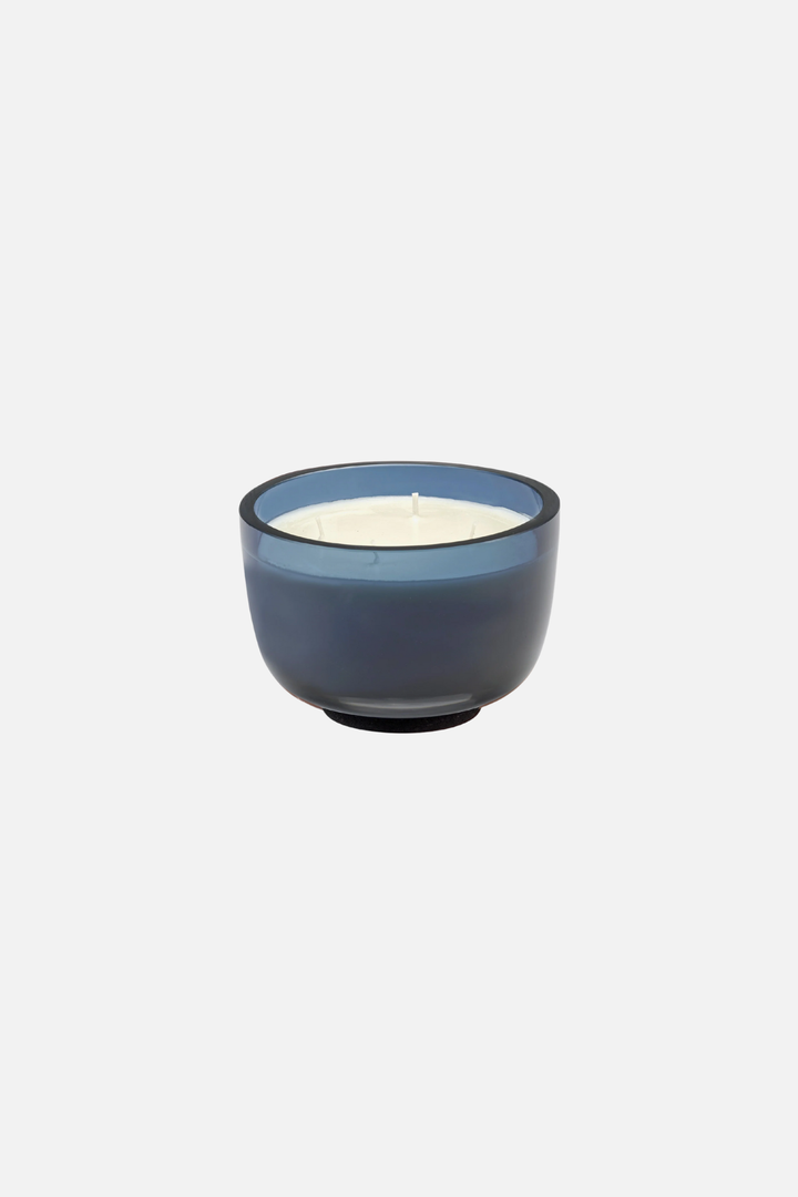 Blue candle holder with a white candle on a light gray background Vincent van duysen Serax