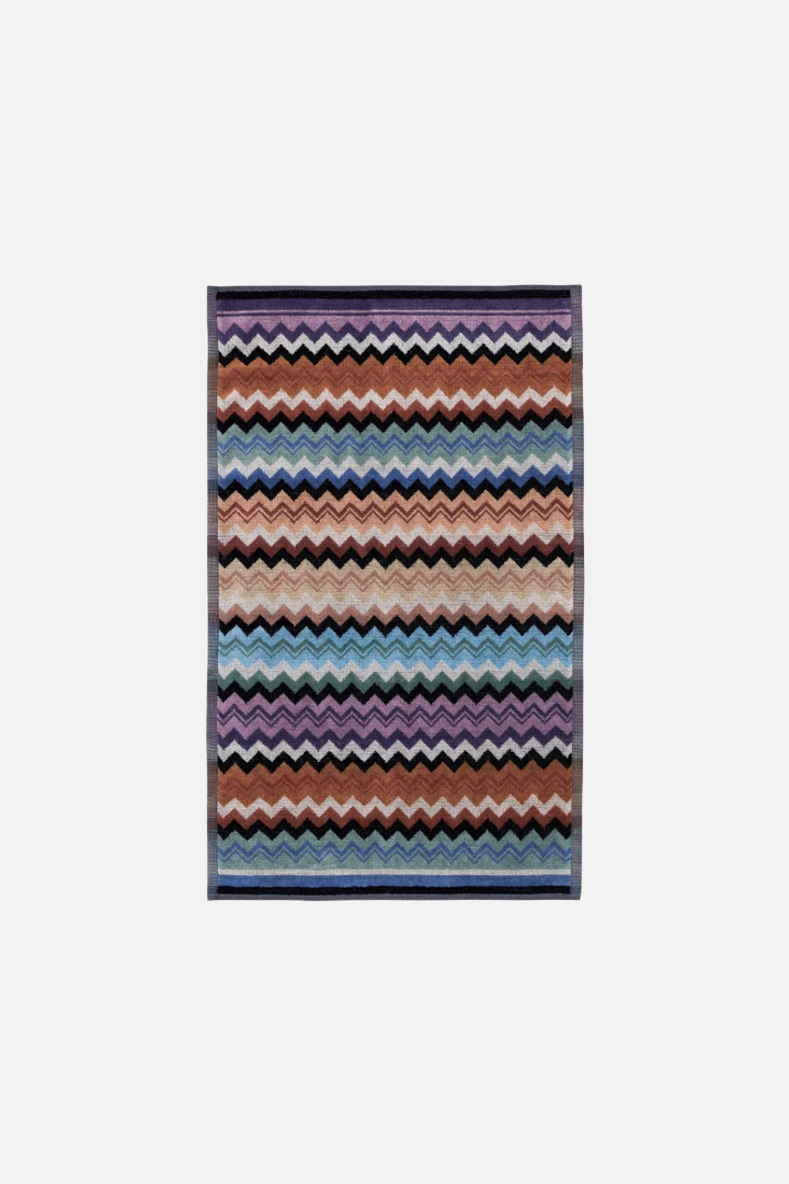 Multi-coloured zigzag patterned towel on a white background