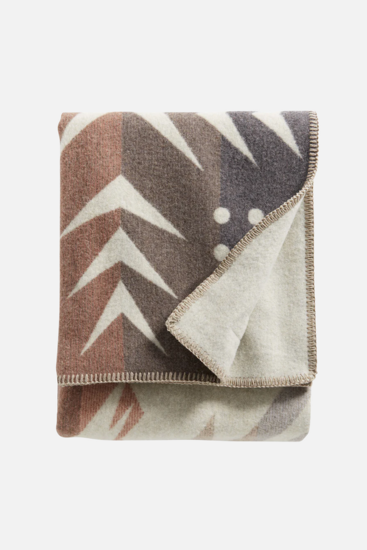 Folded blanket with geometric pattern on a white background